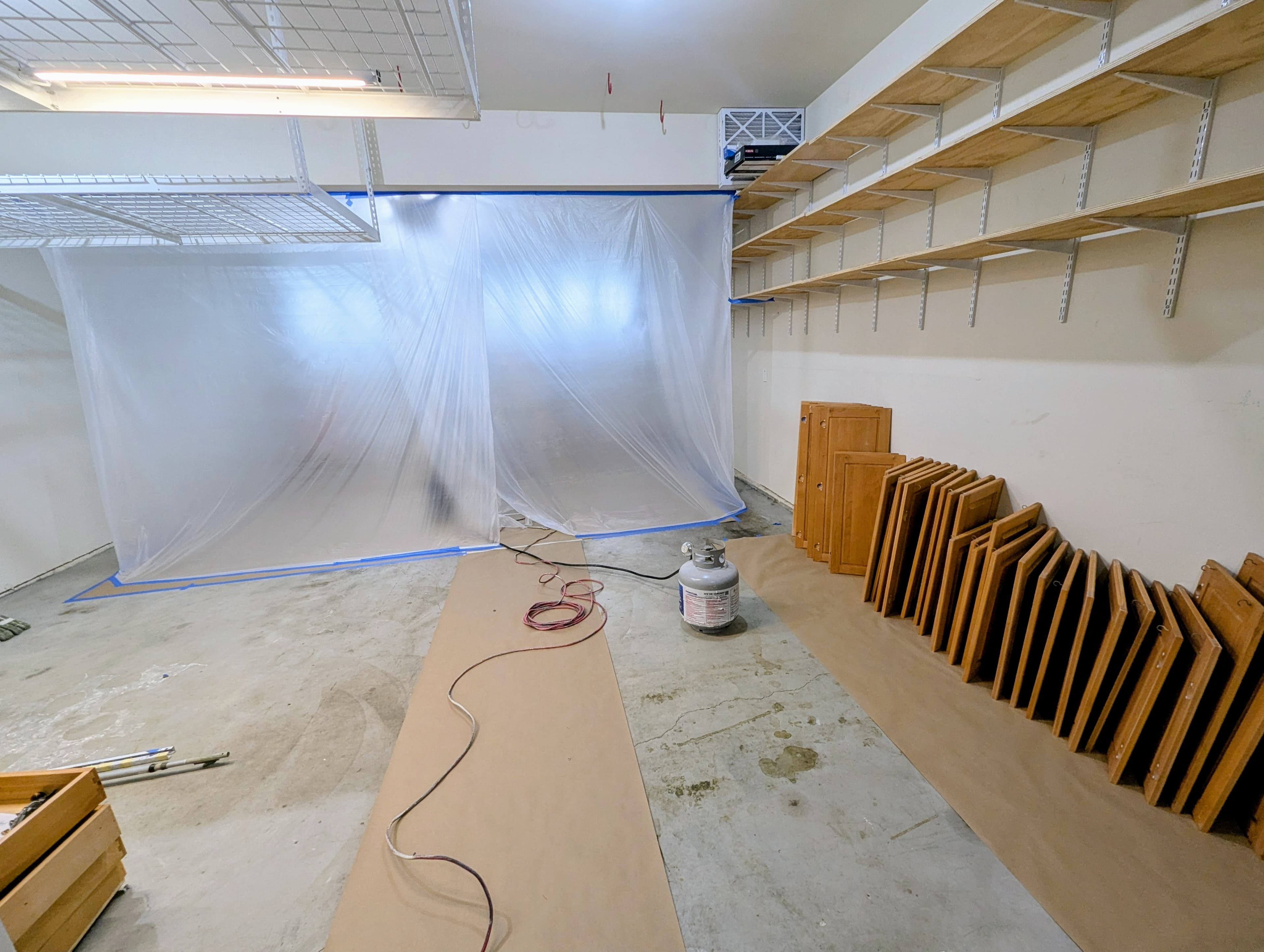 Cabinet doors removed and staged before refinishing in a protected workspace